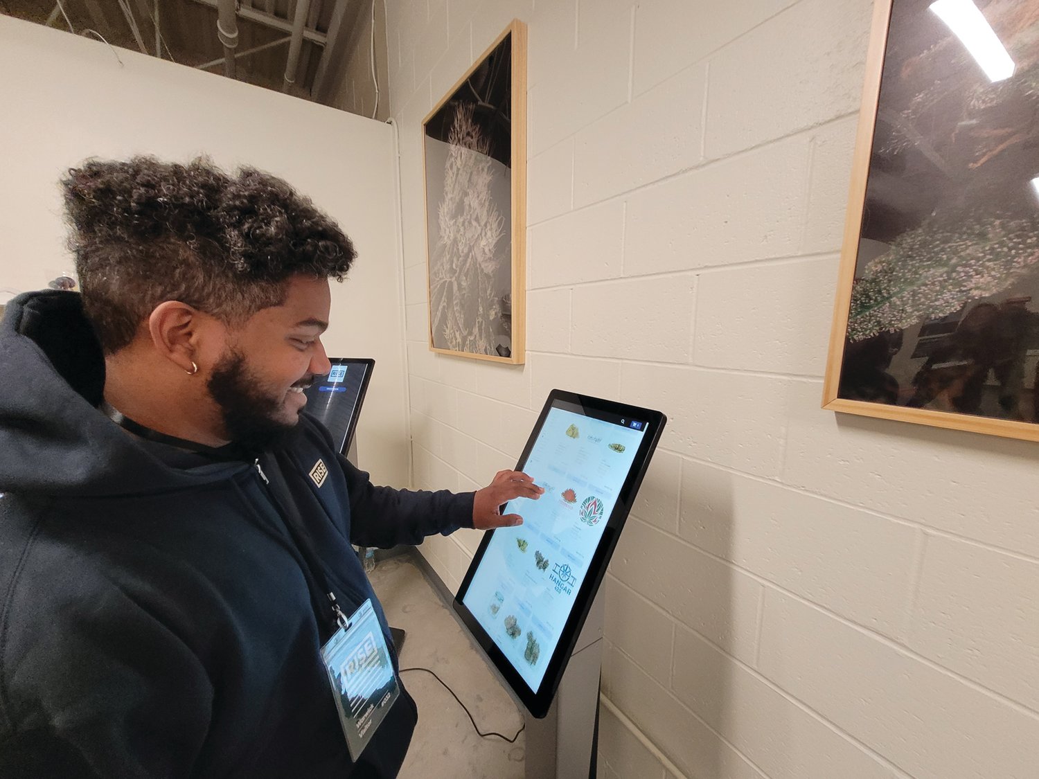 PATIENT & CUSTOMER CARE: Brandon Montero, a RISE Patient Care Specialist (PCS), demonstrates the store’s kiosk ordering system. (Herald photo by Rory Schuler)